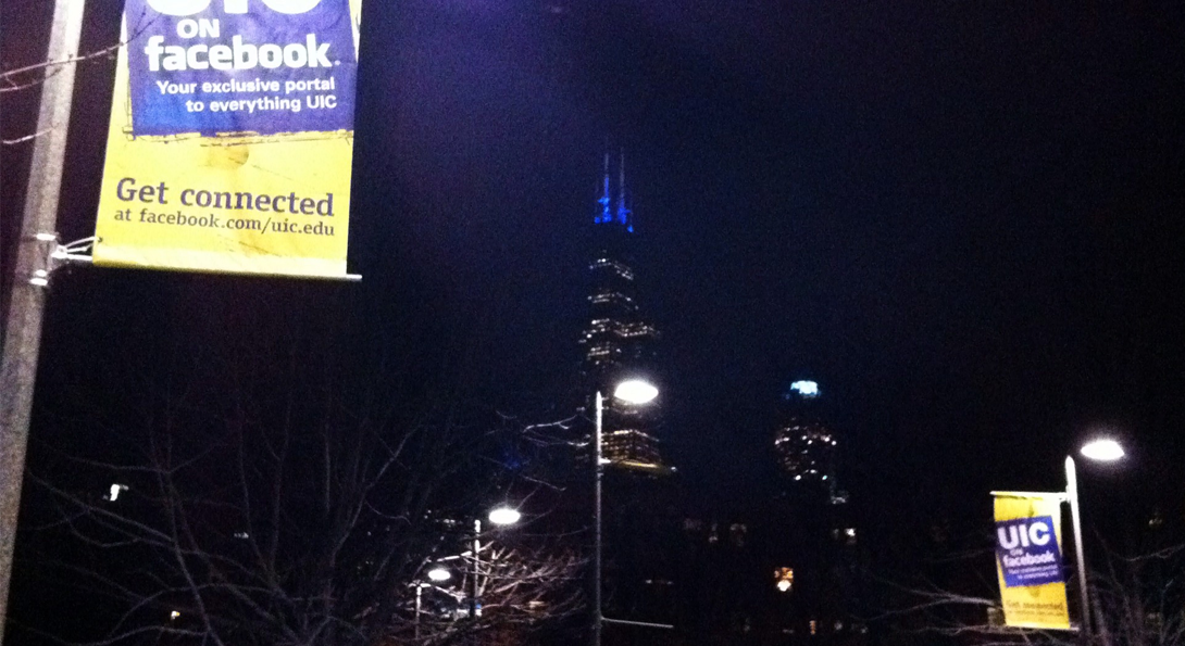 nighttime shot of chicago Willis tower with UIC banners